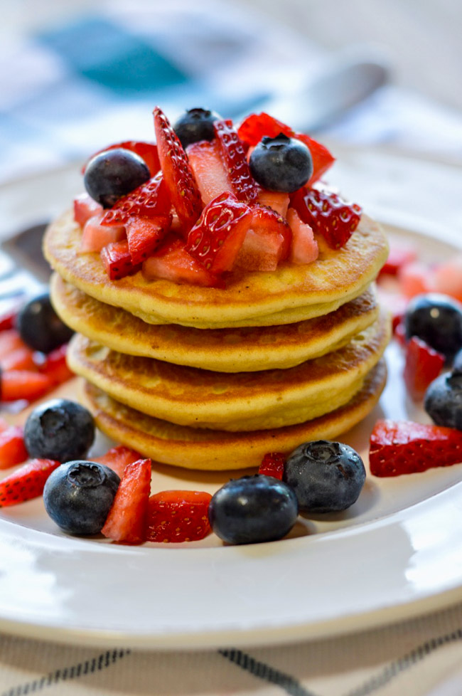Almond flour pancakes topped with strawberries and blueberries.