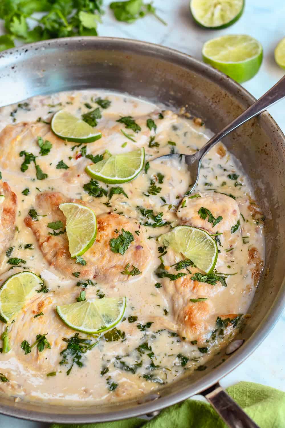 coconut lime chicken in pan with spoon