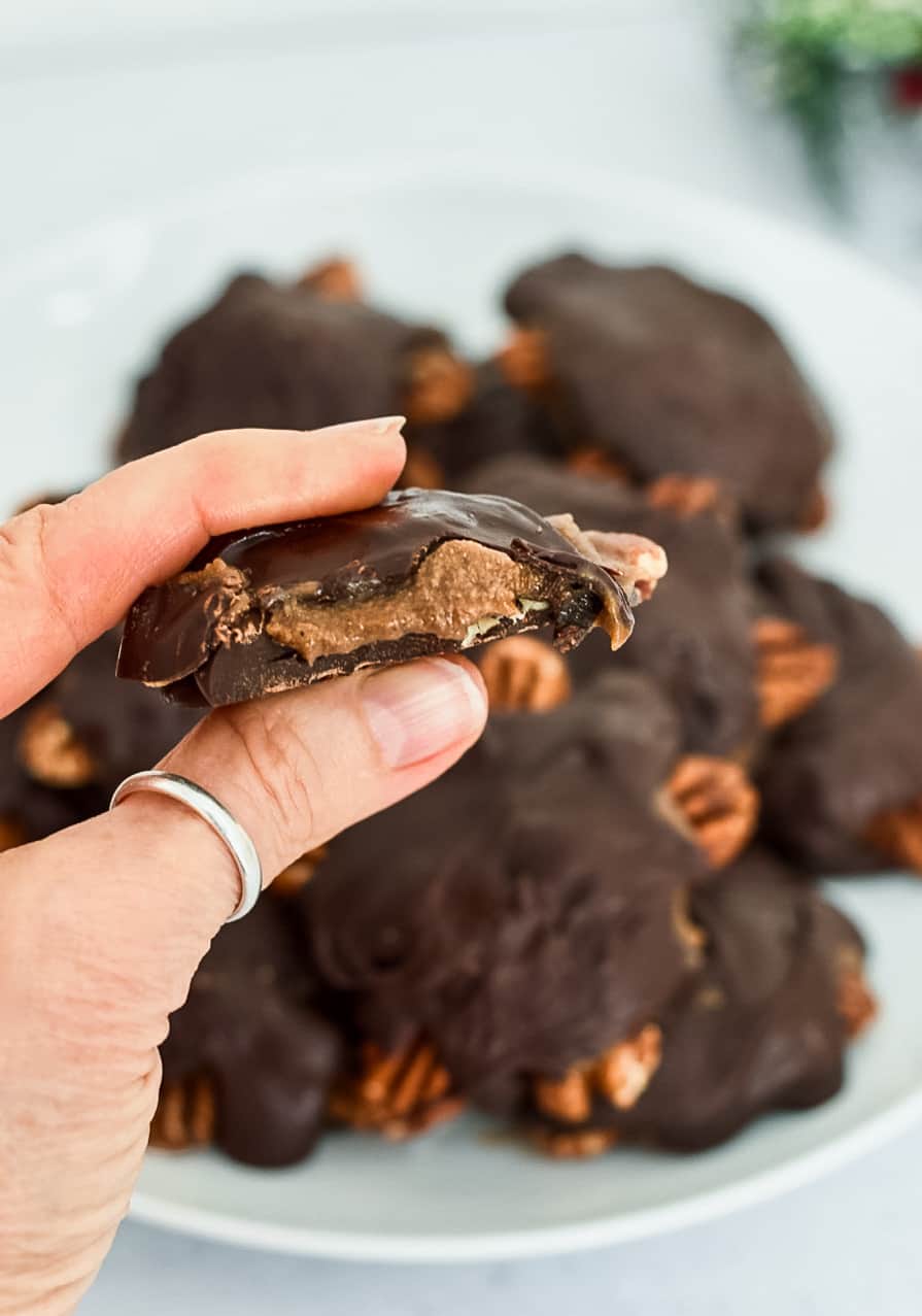 Chocolate Turtle Candies (Paleo Vegan) with bite holding 