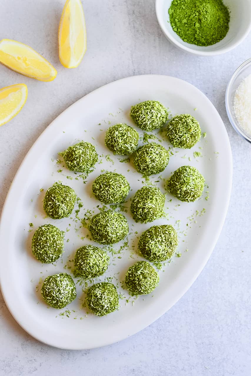 Coconut Matcha Protein Balls on platter with matcha in bowl