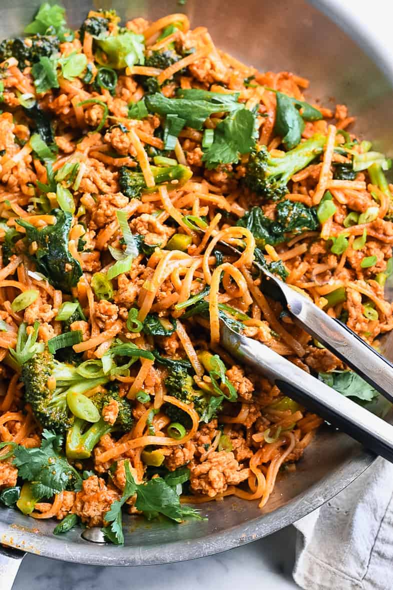 Easy Gochujang Noodles with Vegetables and Chicken close up in pan with tongs