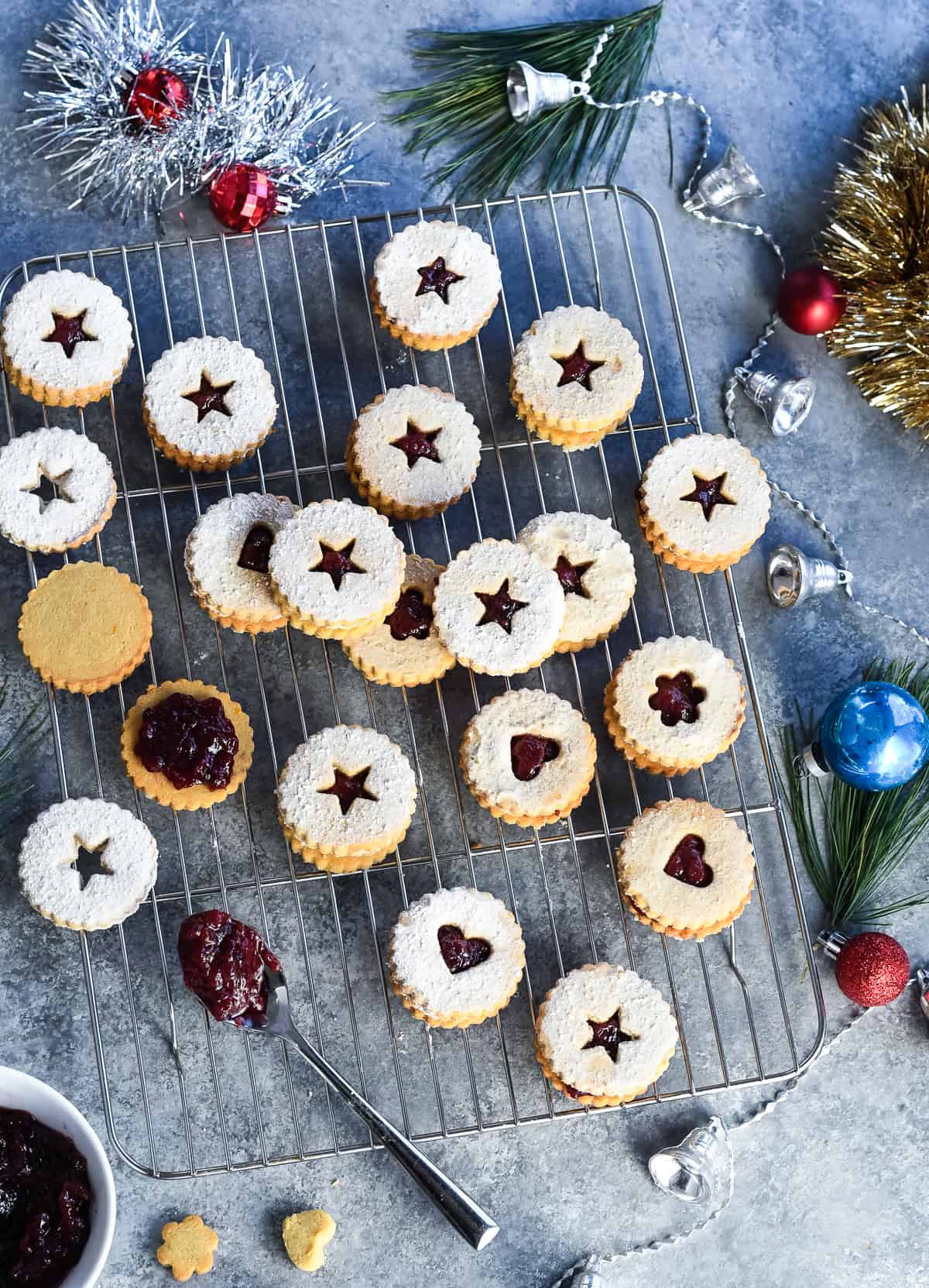 Gluten Free Linzer Cookies on wire rack with holiday decorations