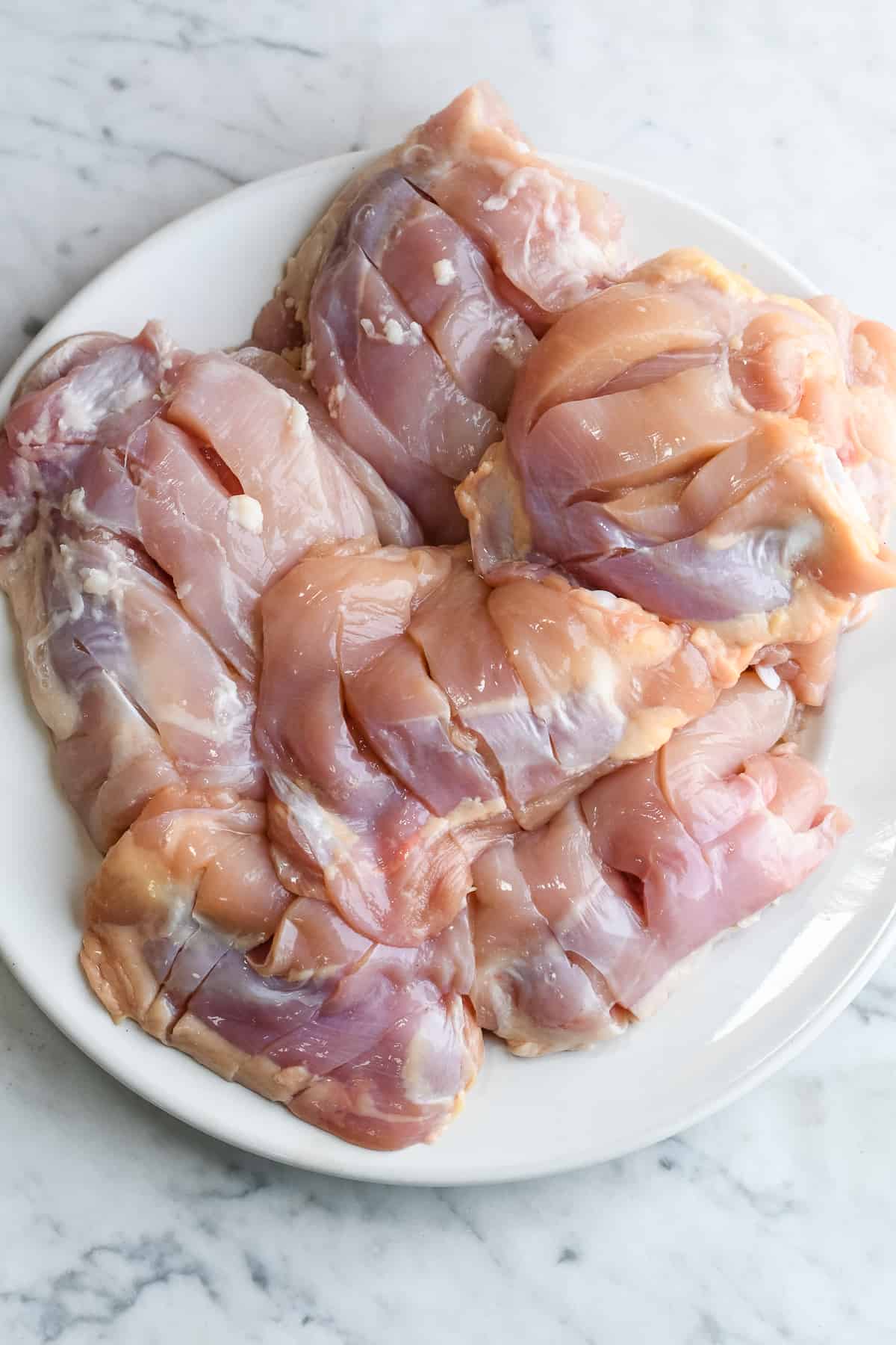 Grilled Tandoori Chicken Thighs raw chicken with slits
