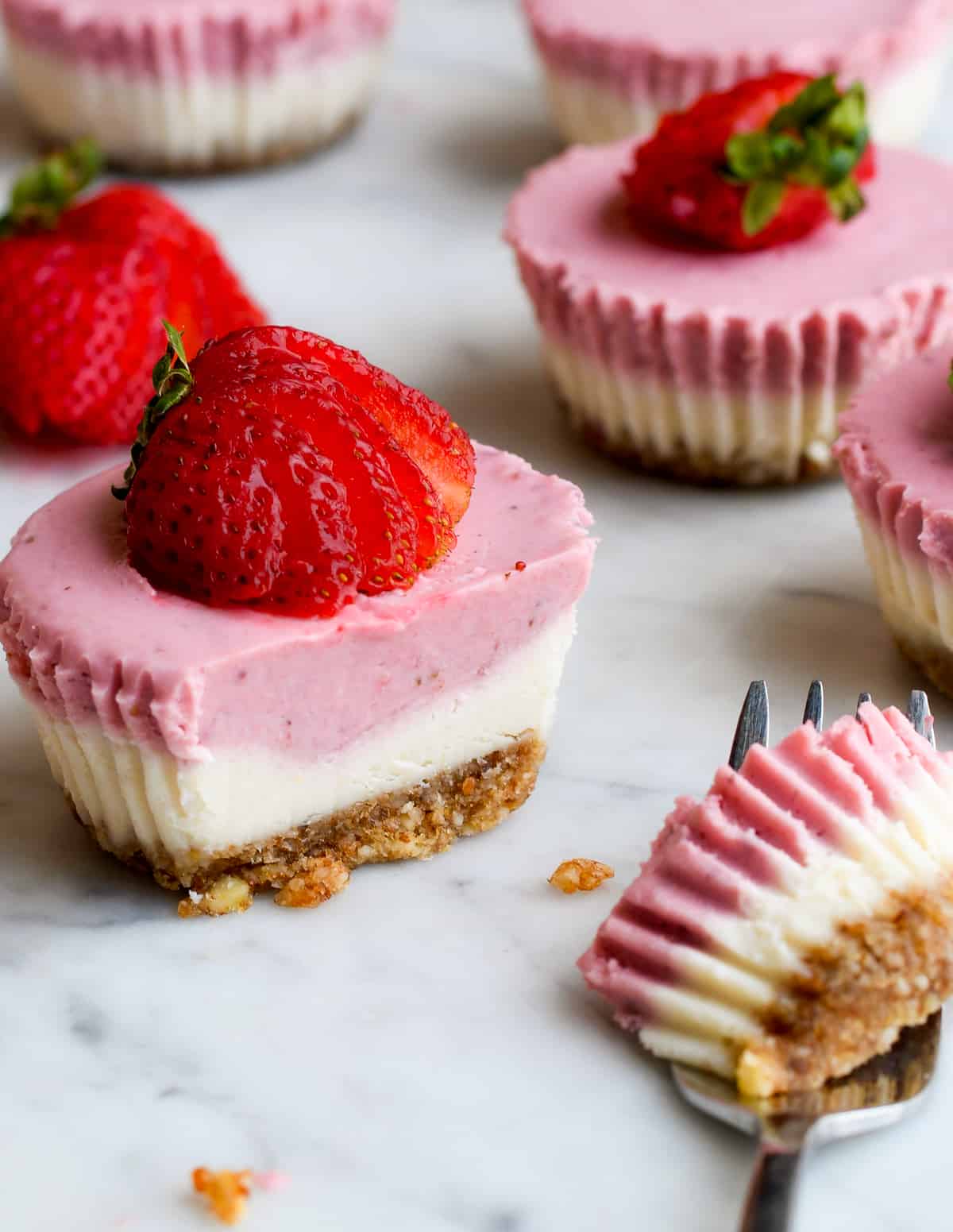 Mini Strawberry Cheesecakes close up with a strawberry fan garnish