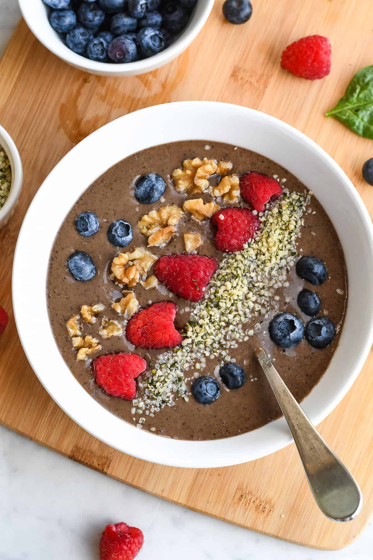 Chocolate Protein Smoothie Bowl bowl alone with spoon, blueberries walnuts hemp seeds and raspberries