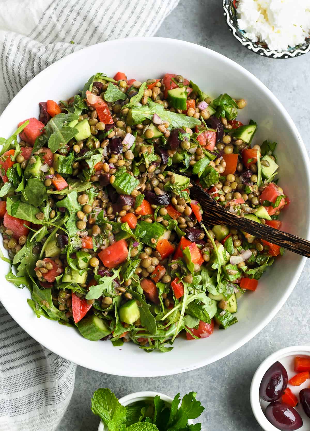 Mediterranean French Lentil Salad in a bowl with serving spoon, overview