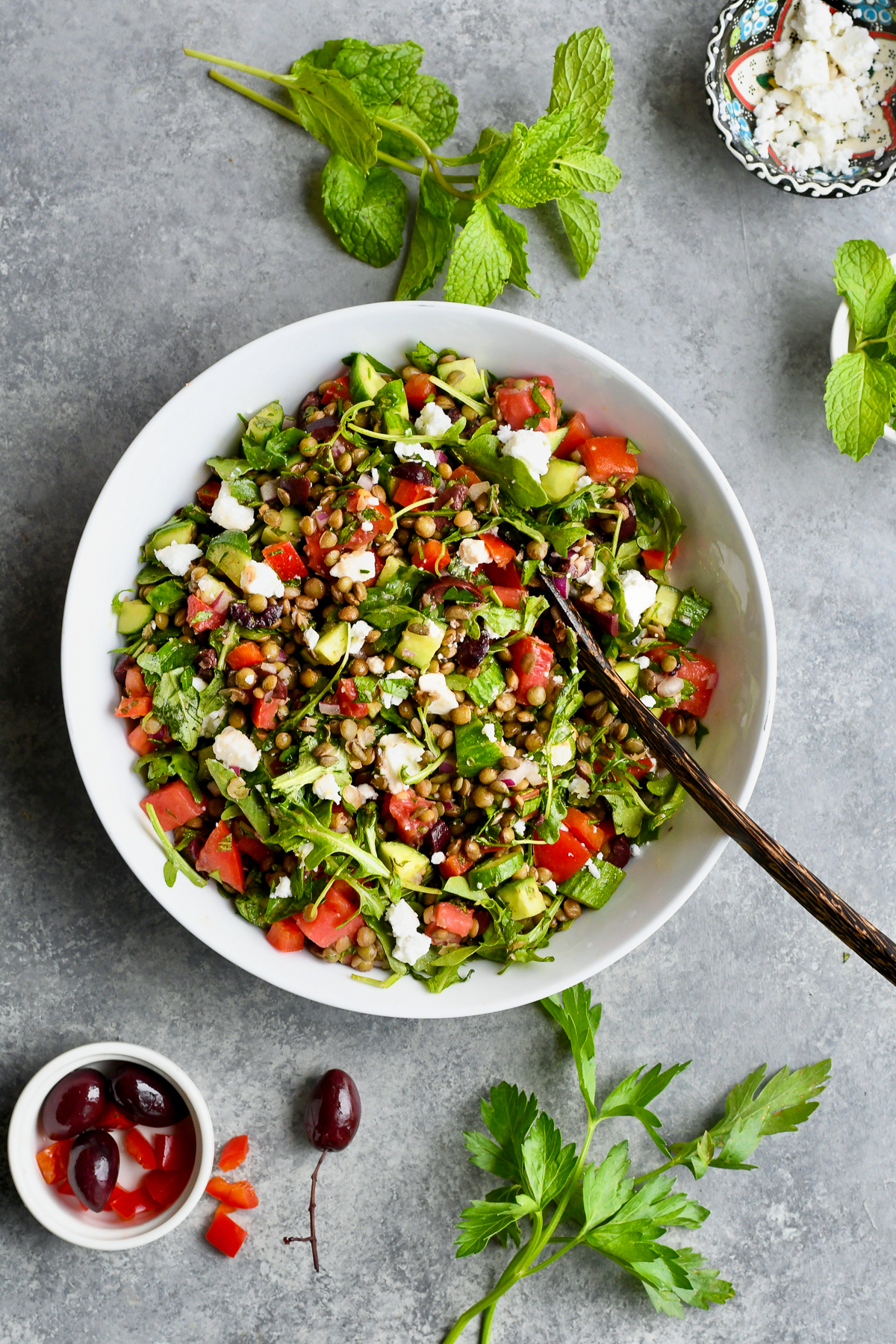 Mediterranean French Lentil Salad overhead shot with mint, parsley and olives on the side