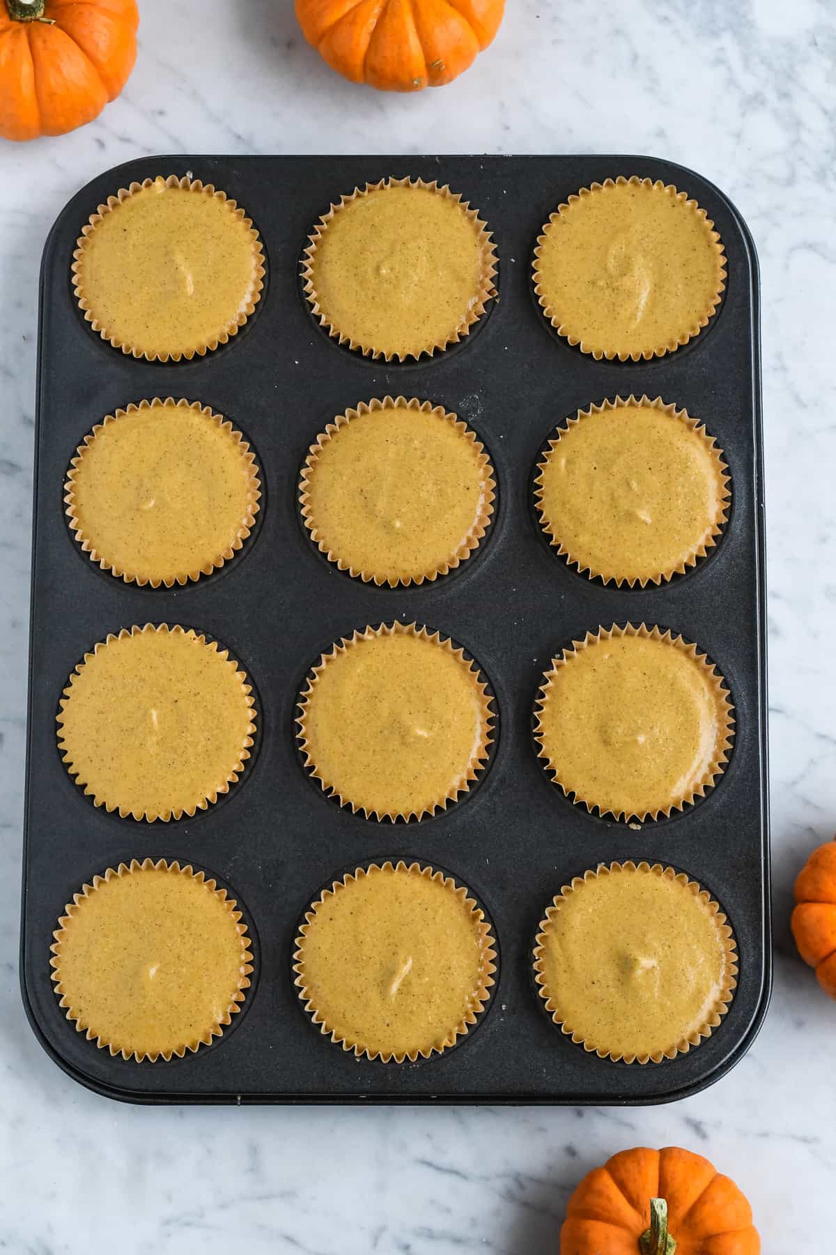 Vegan Mini Pumpkin Cheesecakes in tray filled before baking