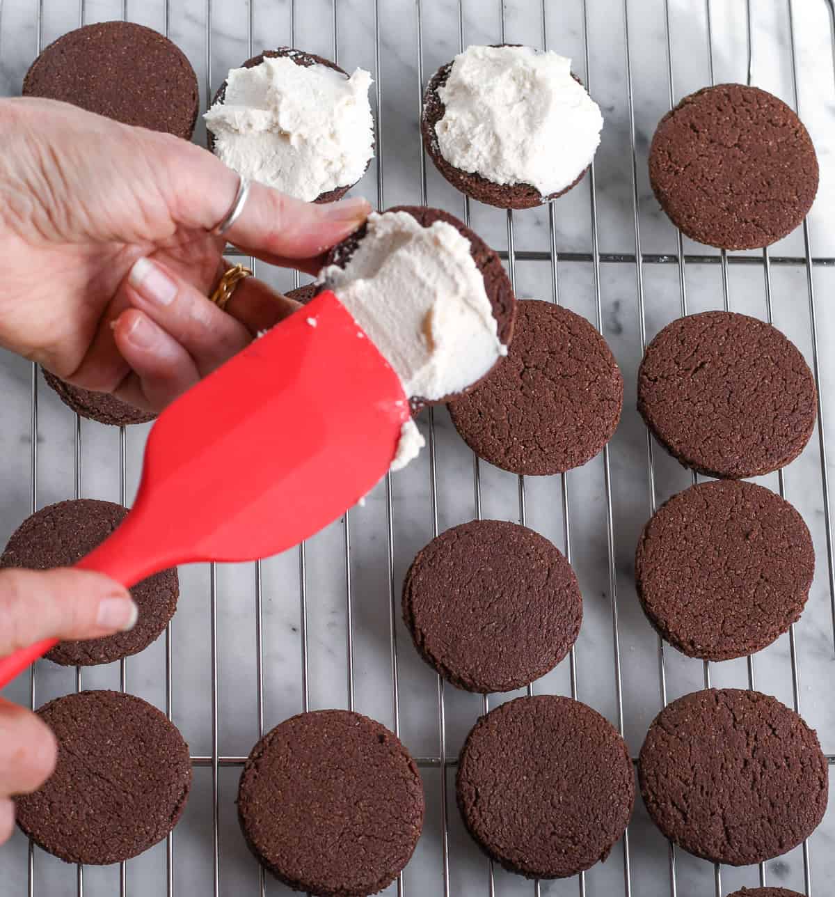 Healthy Homemade Oreos spreading the filling with spatula