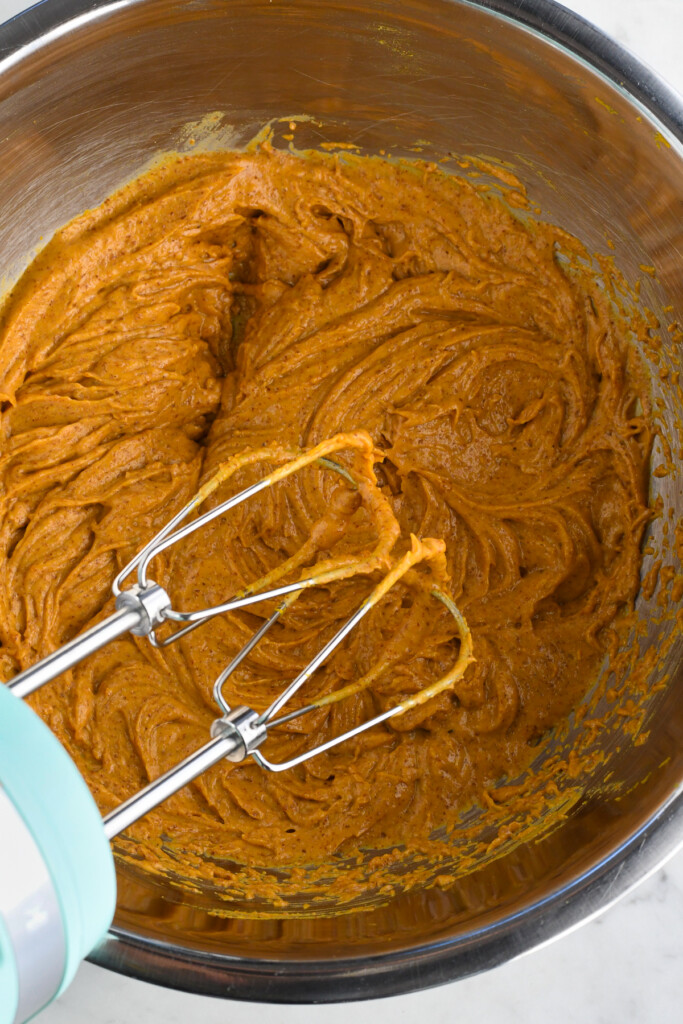 healthy pumpkin brownies beating the eggs and pumpkin with a hand mixer