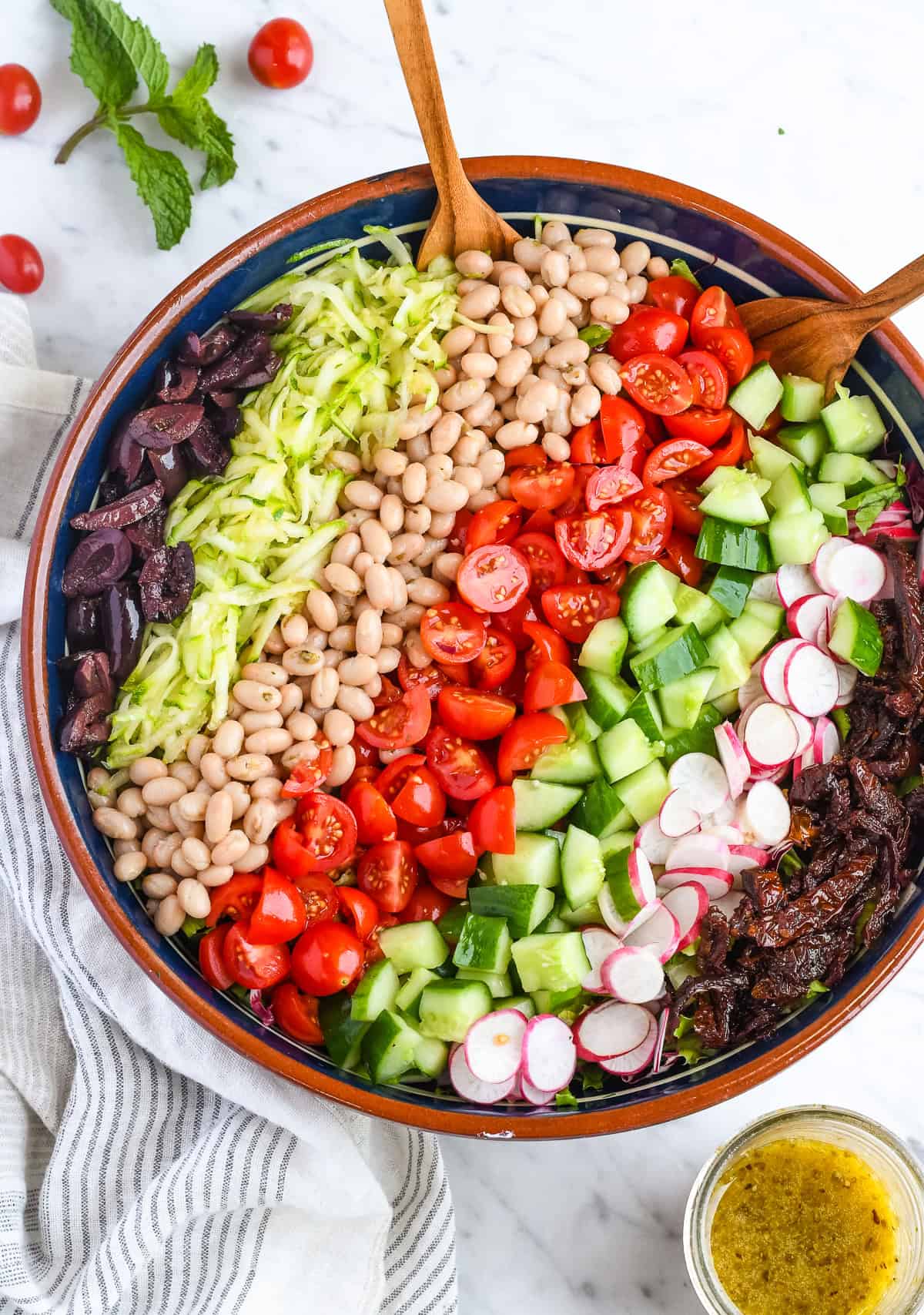 Mediterranean Chopped Salad in a bowl with vegetables in a line