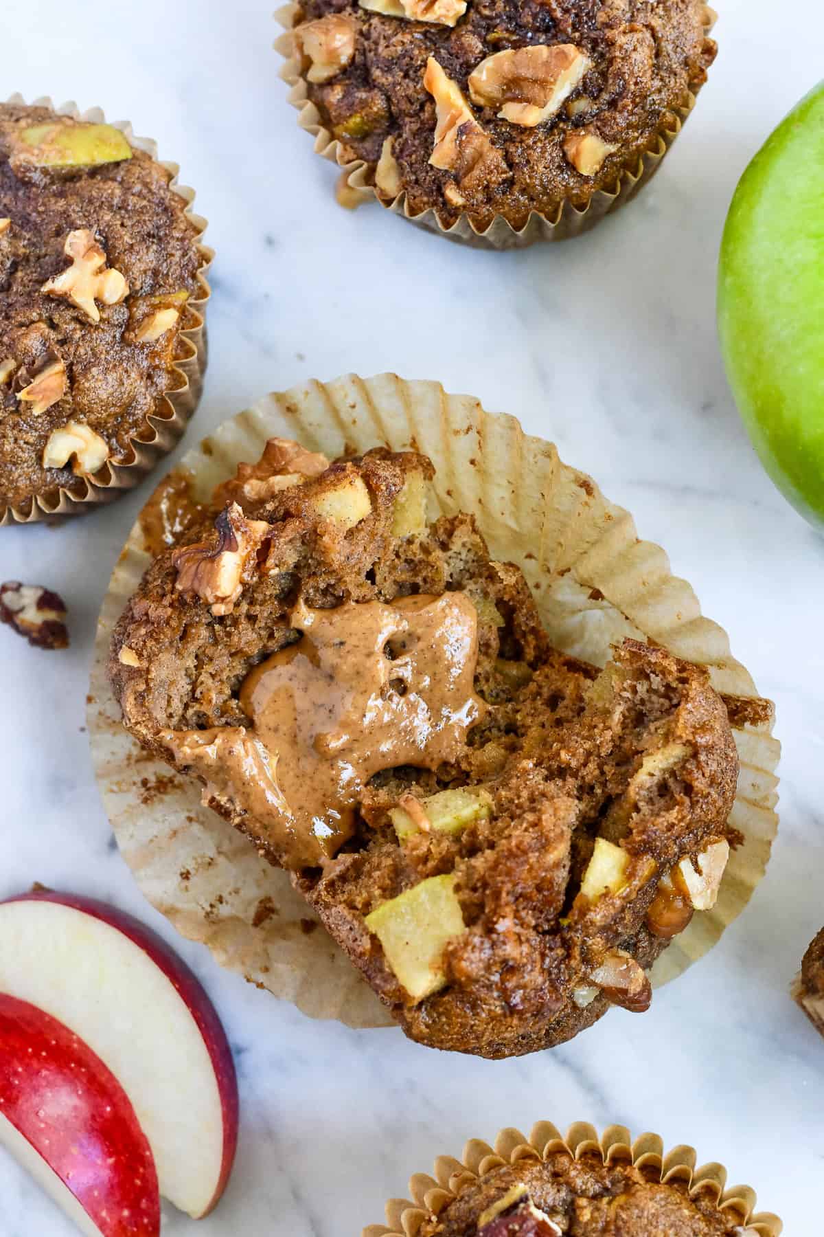 Healthy Apple Muffins muffin broken open with almond butteer