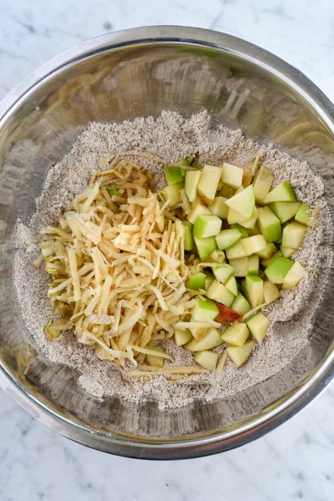 Healthy Apple Muffins grated and chopped apples in bowl with dry ingredients