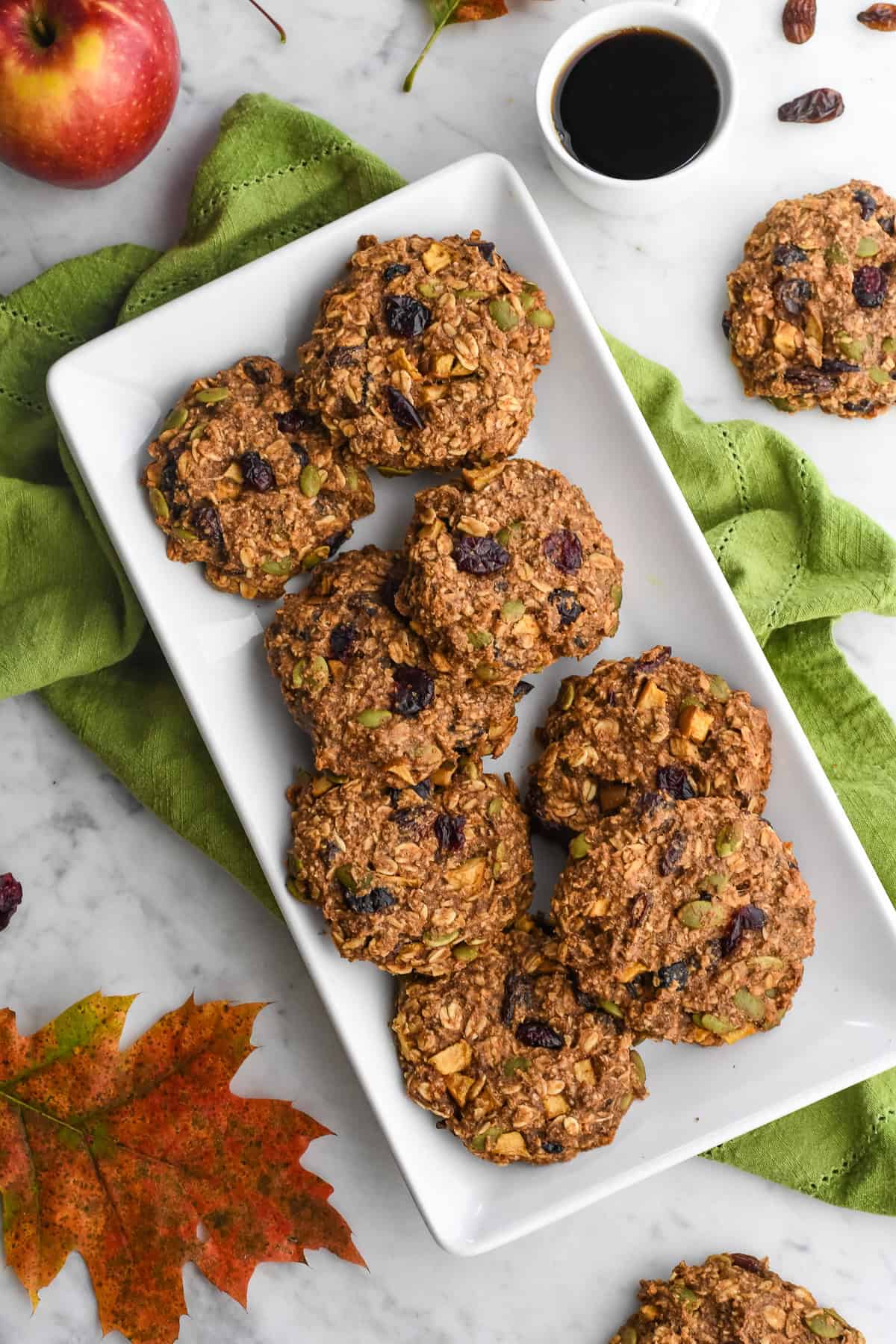 Healthy Apple Breakfast Cookies on a platter with a cup of coffee, a napkin and a fall leaf