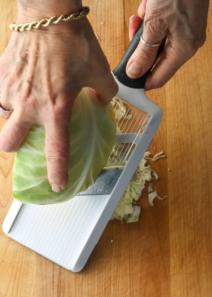 Cabbage Fritters (Gluten Free) hands showing shredding the cabbage