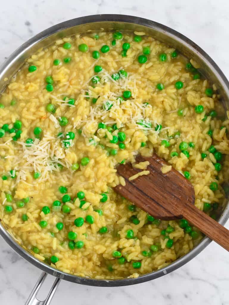 Saffron Risotto with Peas mixing in peas and parmesan
