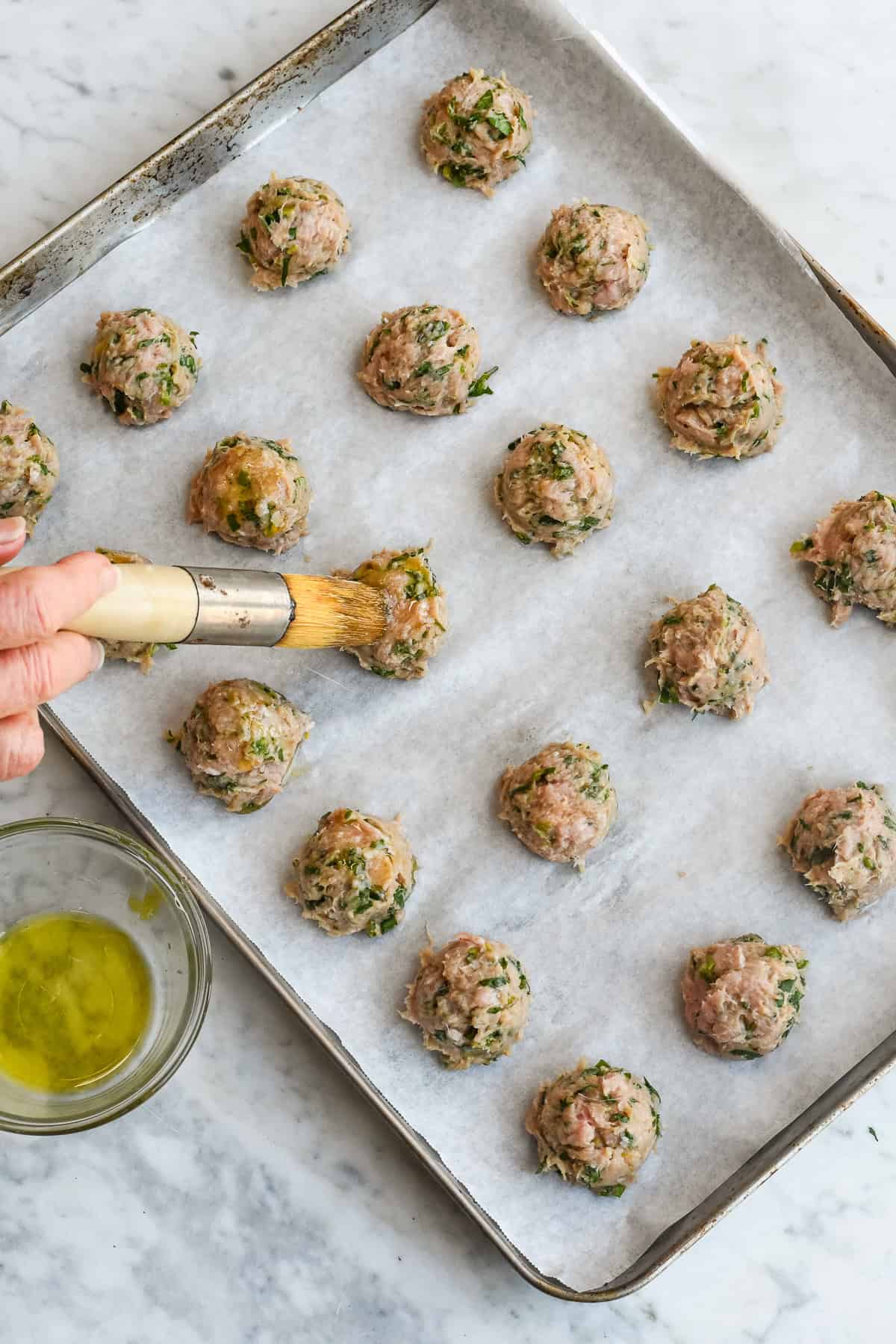 Asian Turkey Meatballs brushing the raw meatballs with oil