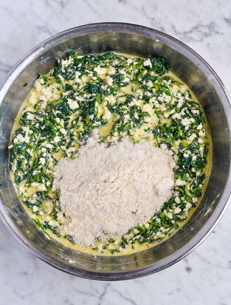 High Protein Spinach Egg Bites filling in a bowl with almond flour being added