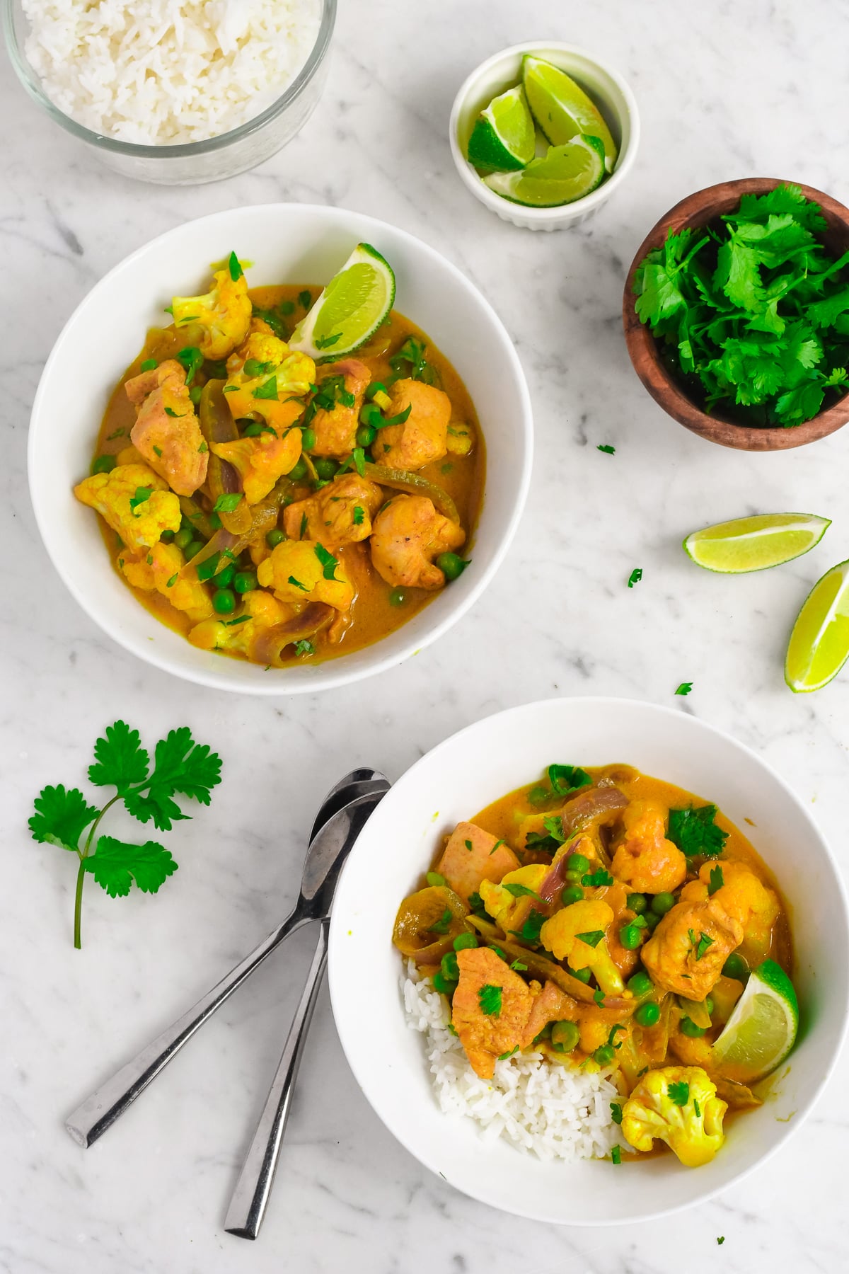 Creamy Pumpkin Curry with Coconut Milk 2 bowls of curry with lime wedges and cilantro in a bowl